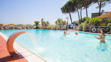 Una piscina al aire libre, sillones reclinables de piscina