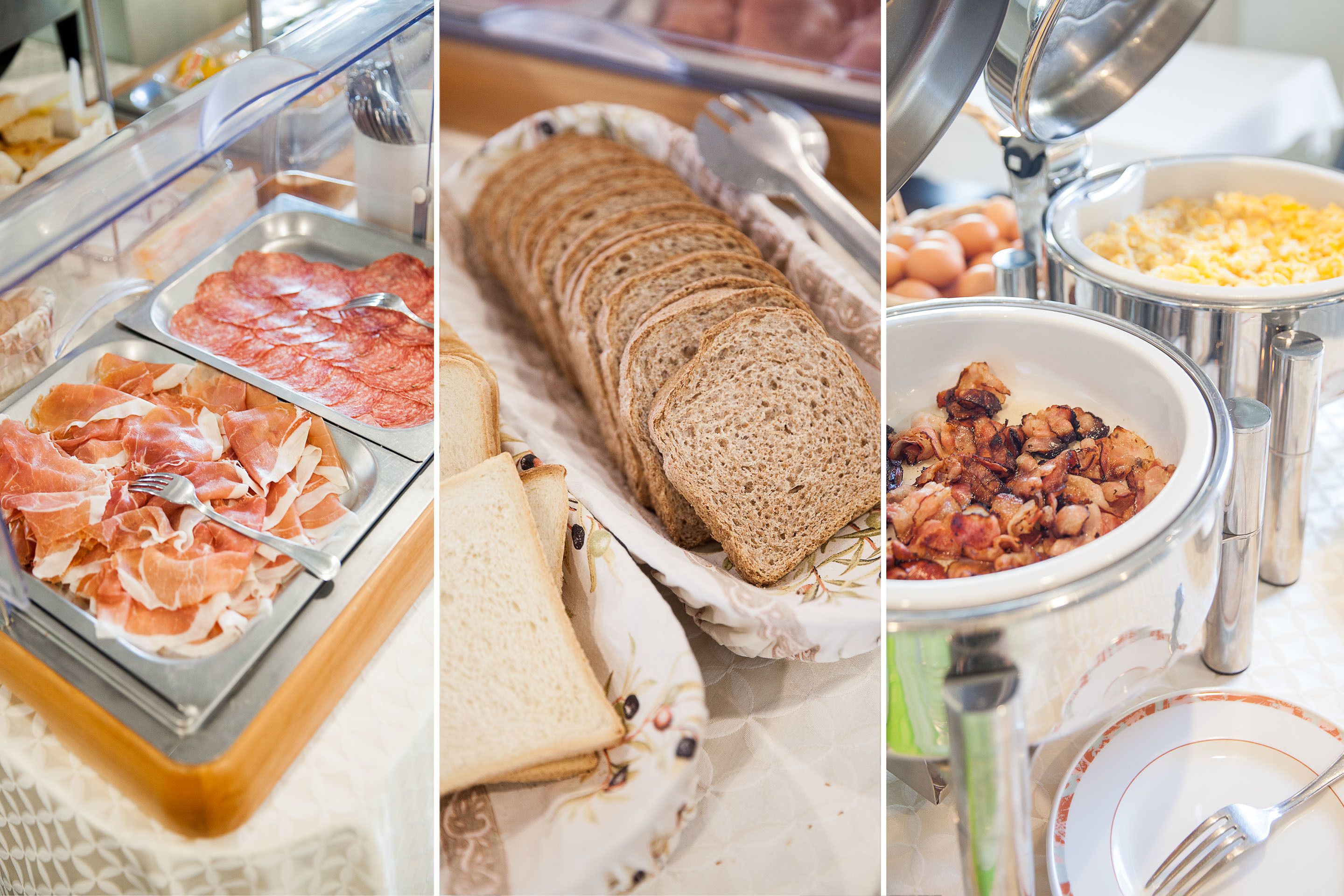 A buffet with various food items including sliced meats, bread, and cooked vegetables.