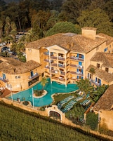 A resort with a central pool, multiple balconies, and a surrounding garden.