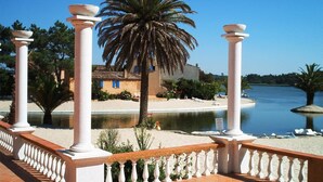 A coastal property with a pool, palm trees, and a beach. - Quinta da Lagoa (Mira)