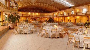 A spacious banquet hall with multiple round tables set for dining, large potted plants, and a high ceiling with decorative drapery. - Quinta da Lagoa (Mira)