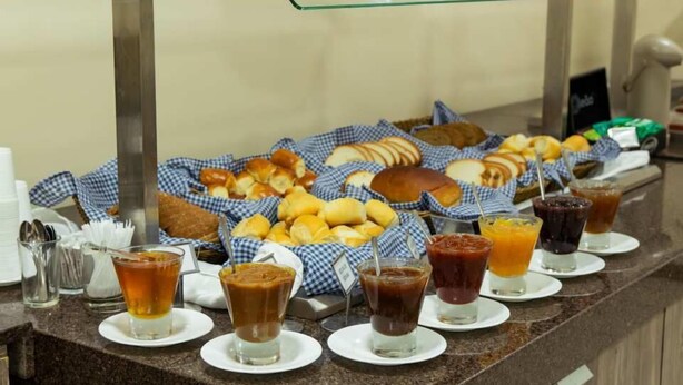A buffet with various breads, pastries, and beverages. - Umbu Hotel Porto Alegre (Porto Alegre)