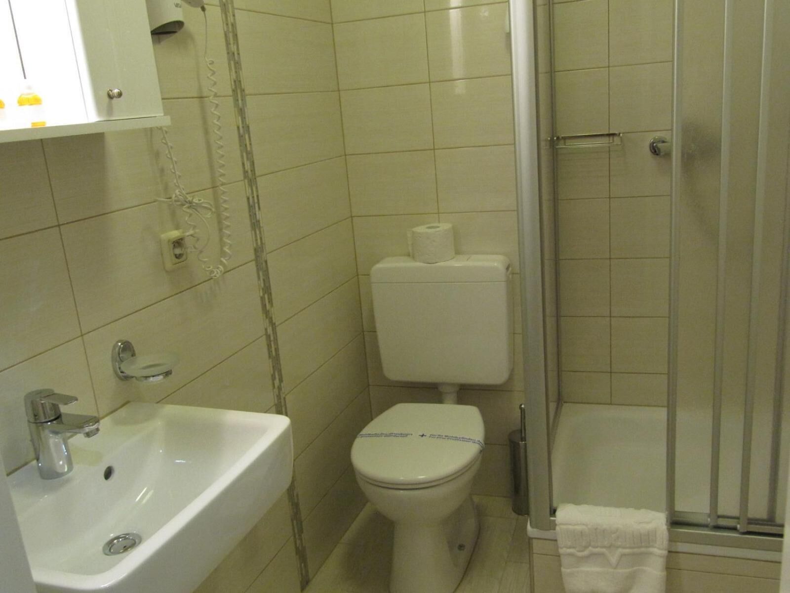 Un baño con lavamanos, inodoro y ducha.