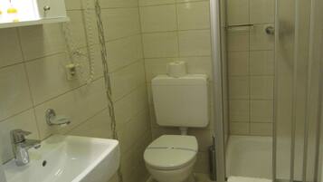 Un baño con lavamanos, inodoro y ducha.