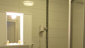 A bathroom with a sink, mirror, hairdryer, and toilet. - Hotel am Hauptbahnhof (Schwerin)