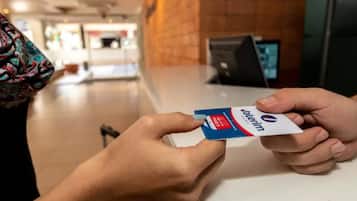 Una persona sostiene una tarjeta Valerim en un mostrador en un espacio público.