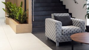 Un interior moderno con una escalera, un sofá estampado y una lámpara decorativa.