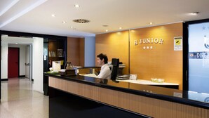 A reception desk with a wooden panel and a glass partition.