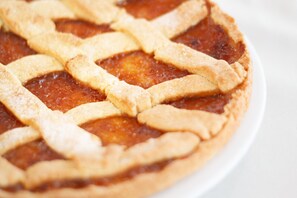 Une tarte dont la croûte est décorée d’un motif en treillis, présentée sur une assiette blanche.