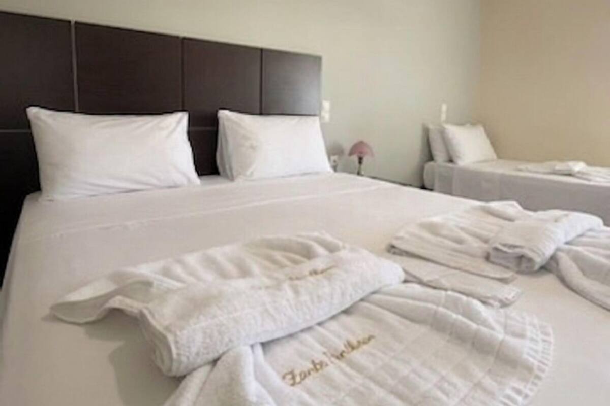 A hotel room with a large bed, two bedside tables, and a headboard.