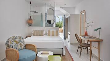Un dormitorio moderno con una cama grande, un escritorio, una silla y una mesita.