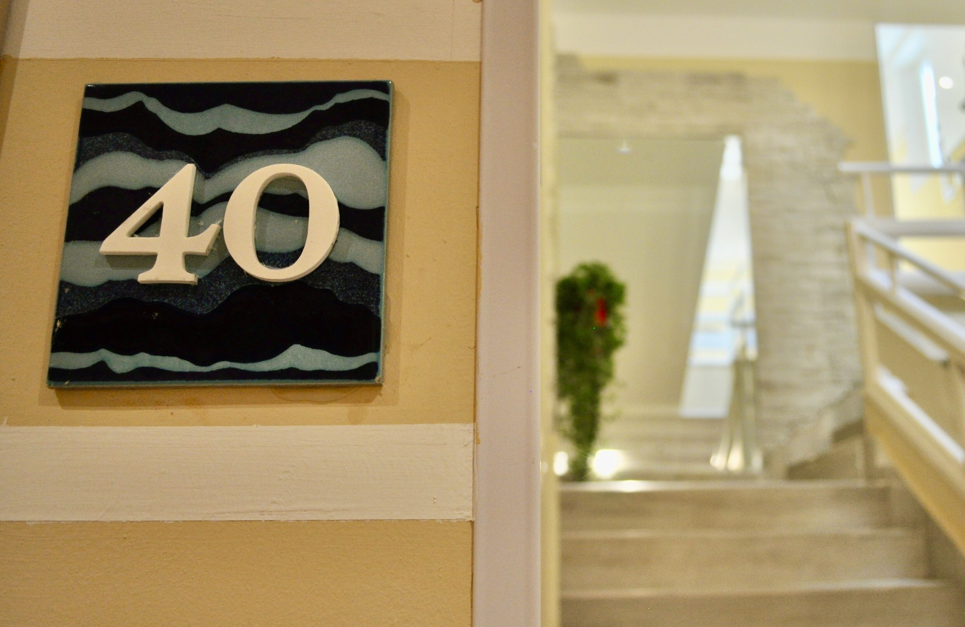 A wall-mounted sign with the number 40, a staircase, and a railing.