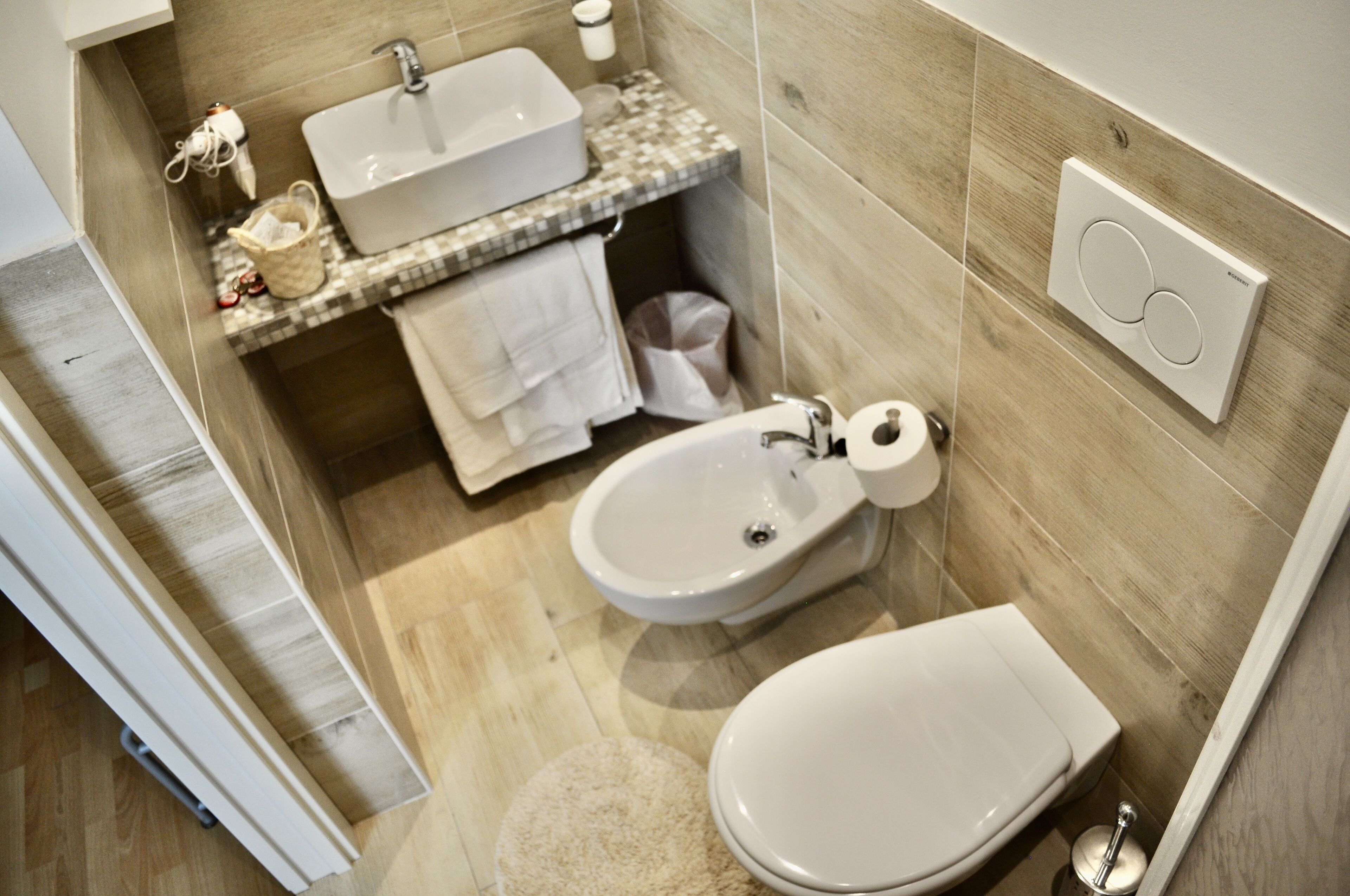 A modern bathroom with a sink, bidet, and toilet.