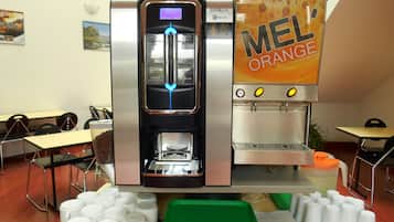 A coffee machine with multiple drink options and a menu display, surrounded by tables and chairs in a cafe setting.