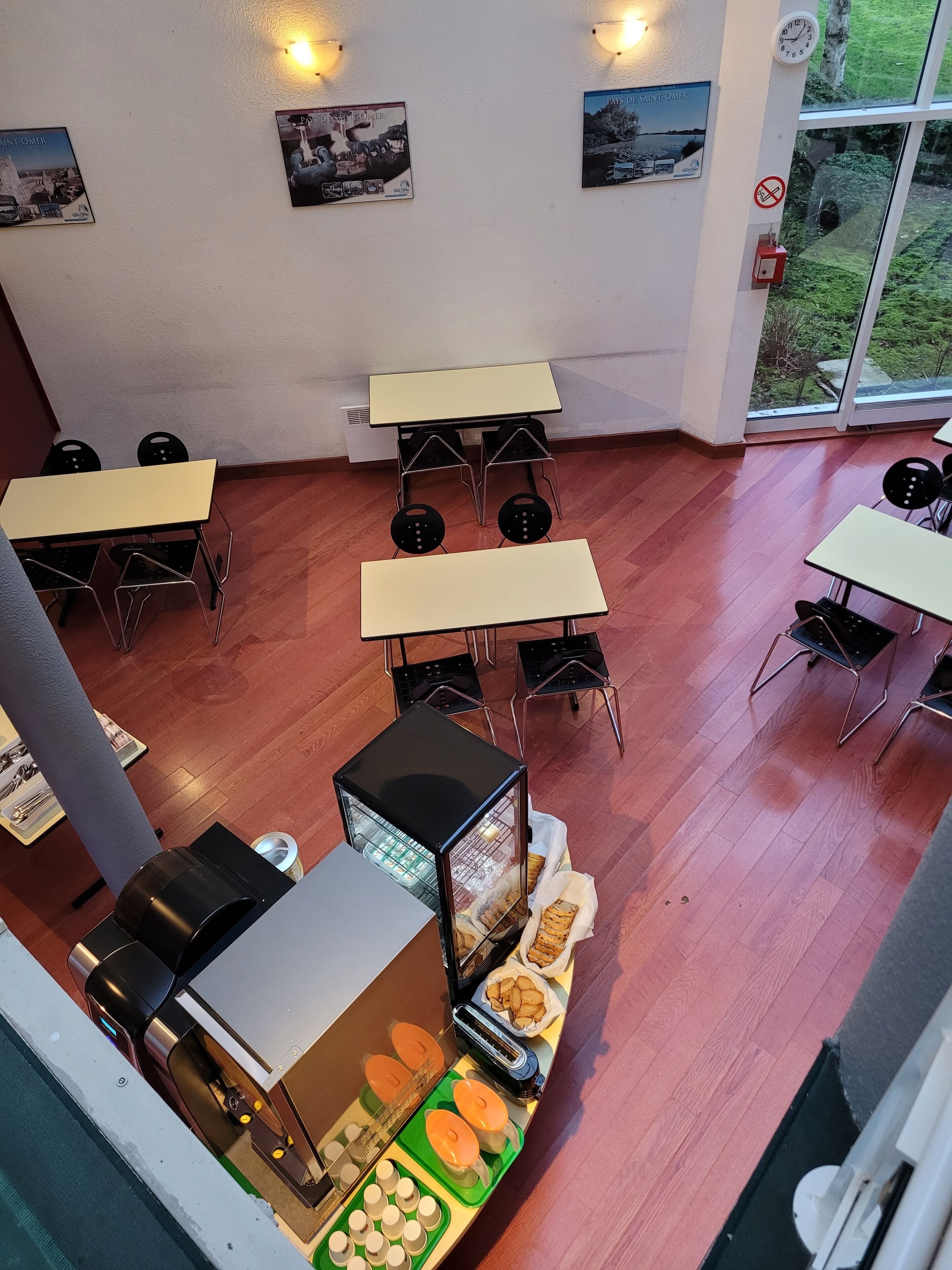 Ein Essbereich mit Tischen und Stühlen, einer Grillstation und Blick durch die Glastür.