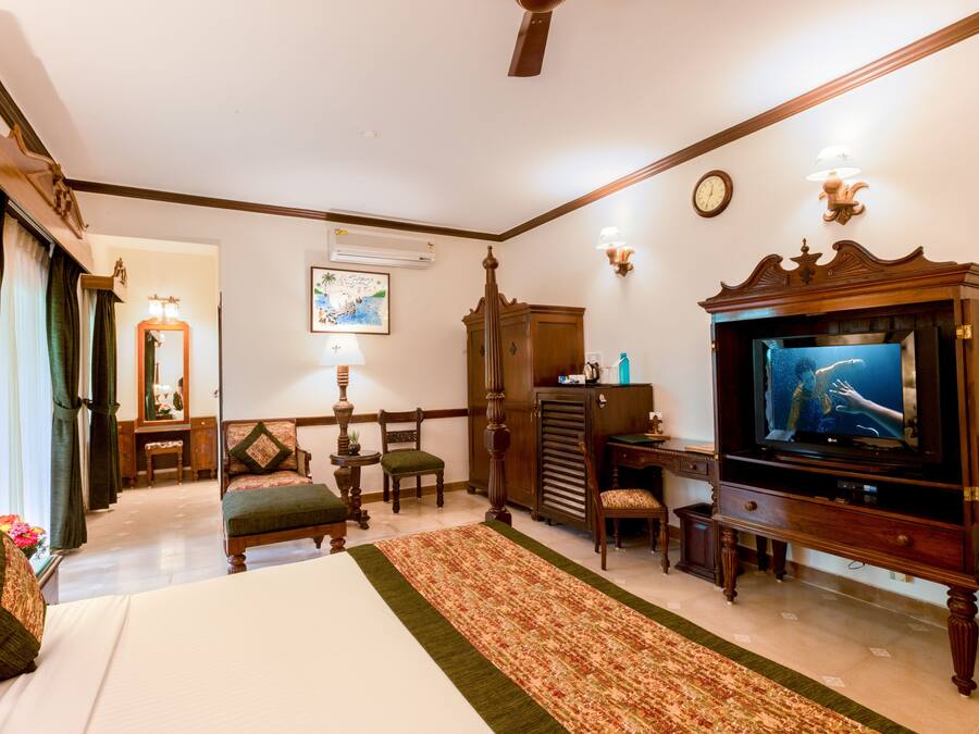A hotel room with a bed, a television, a desk, and a chair.