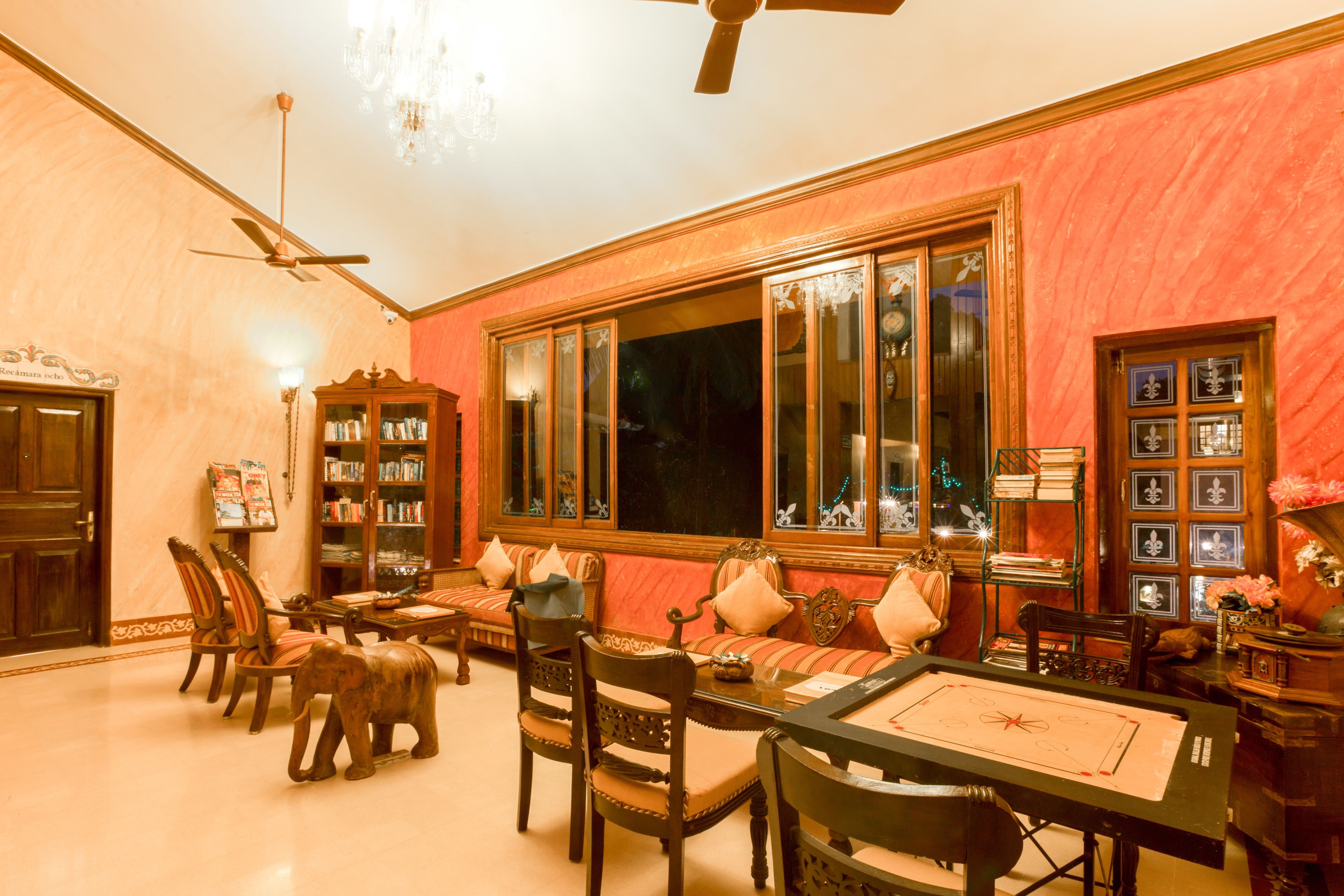A room with a large window, a ceiling fan, a wooden cabinet, and a sofa.