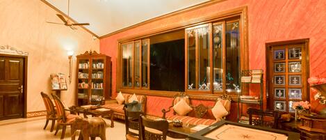 A room with a large window, a ceiling fan, a wooden cabinet, and a sofa.