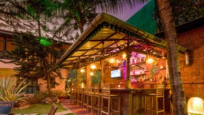 An outdoor bar area with a covered seating area, a bar counter, and a TV screen. - Casa Severina (Calangute)