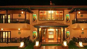 A two-story building with a central entrance, balconies, and a well-lit facade. - Casa Severina (Calangute)