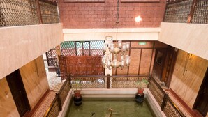 A multi-level building with a central courtyard featuring a koi pond, steps leading to the upper levels, and a decorative fountain. - Casa Severina (Calangute)