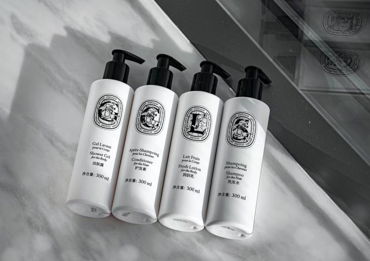 Four bottles of shower gel on a marble surface.