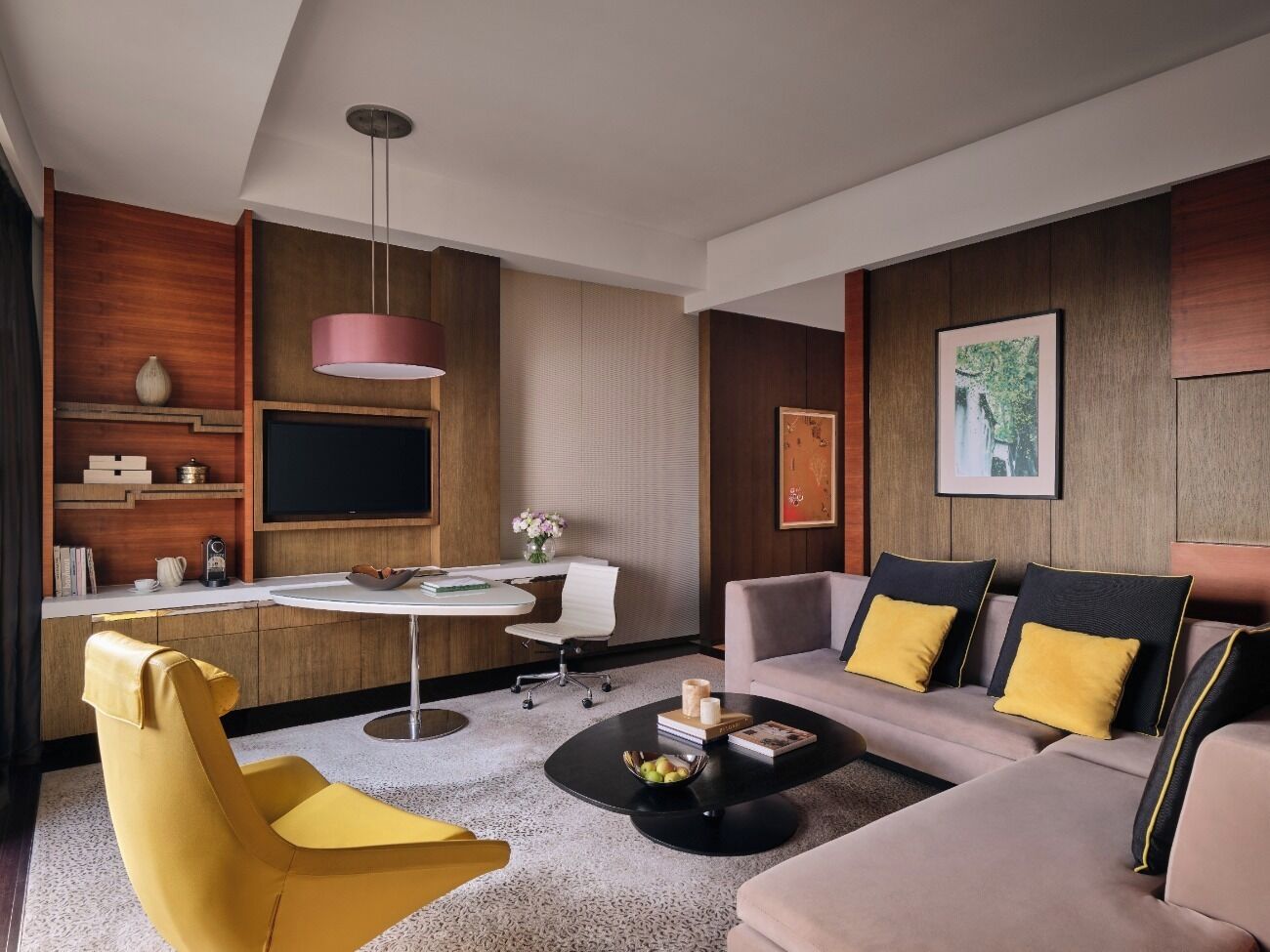 A modern living room with a sofa, yellow armchair, and a round coffee table.
