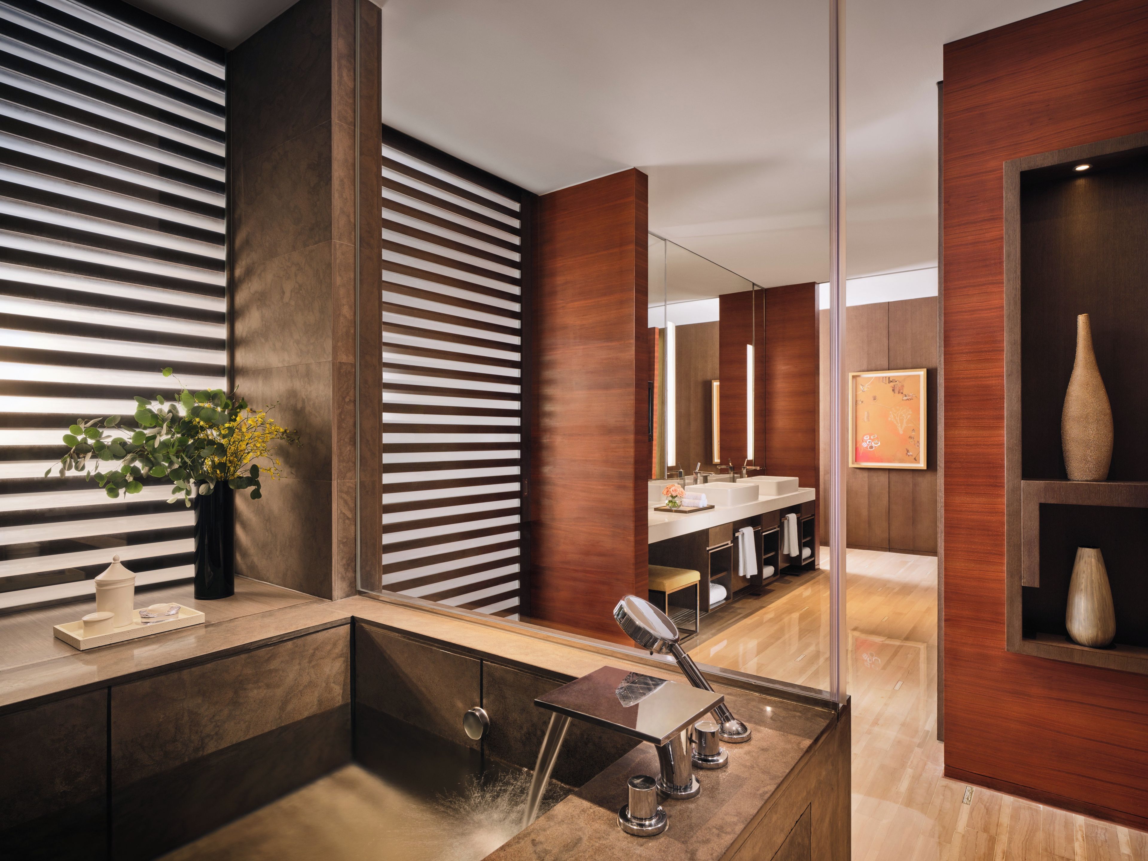 Un baño moderno con un espejo grande, un lavabo con grifo y una zona de ducha.