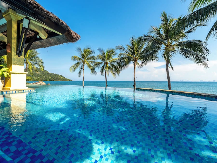 Een buitenzwembad, parasols bij het zwembad en ligstoelen