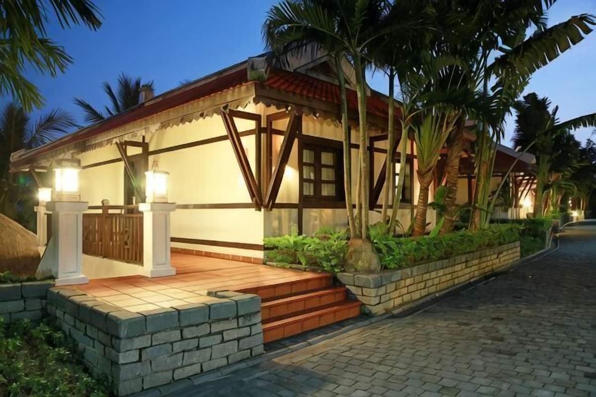 A traditional-style building with a wooden facade, a brick entrance, and a paved pathway.