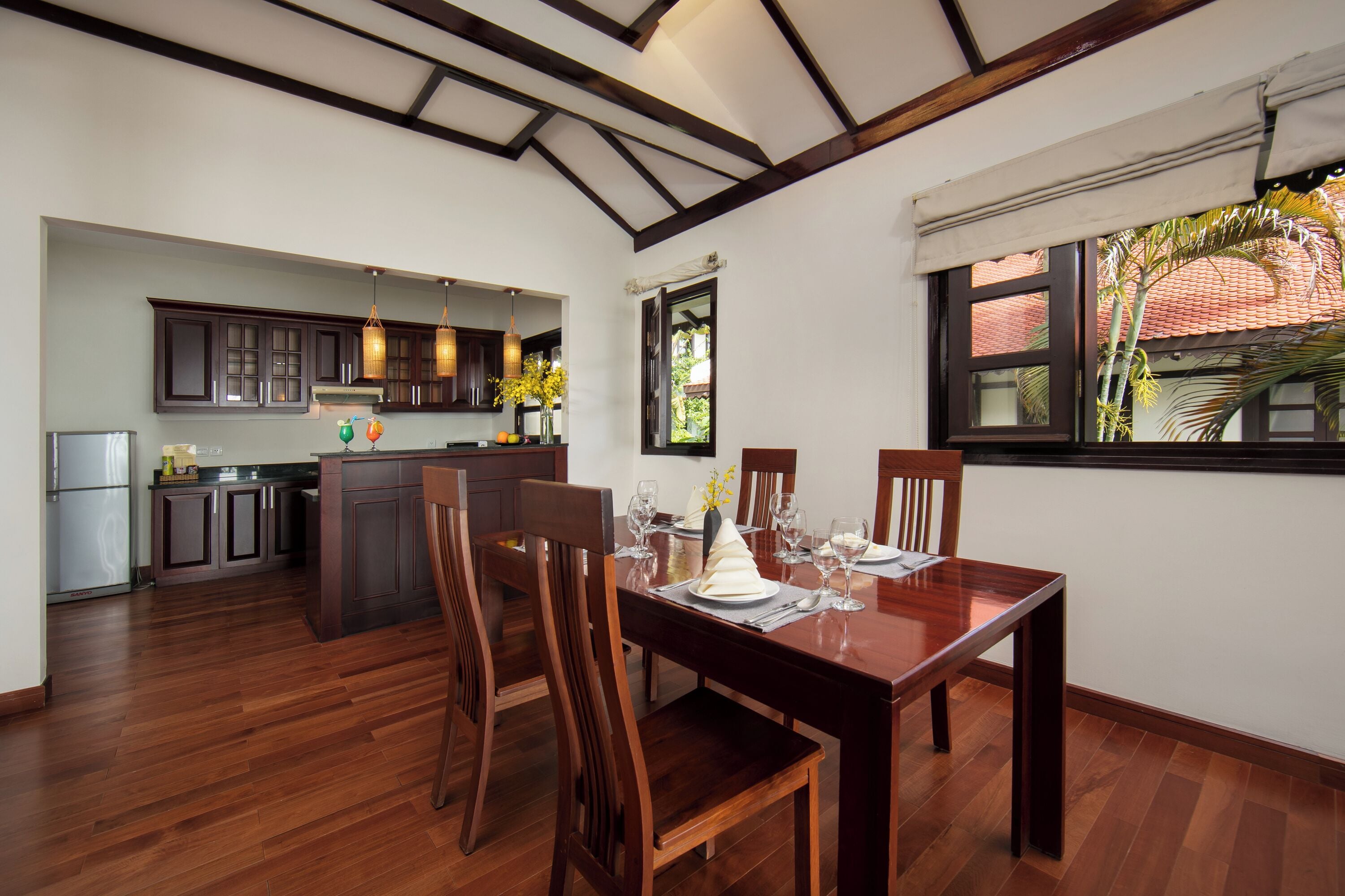 Cozinha ampla com armários de madeira e área de jantar com mesa e cadeiras de madeira.