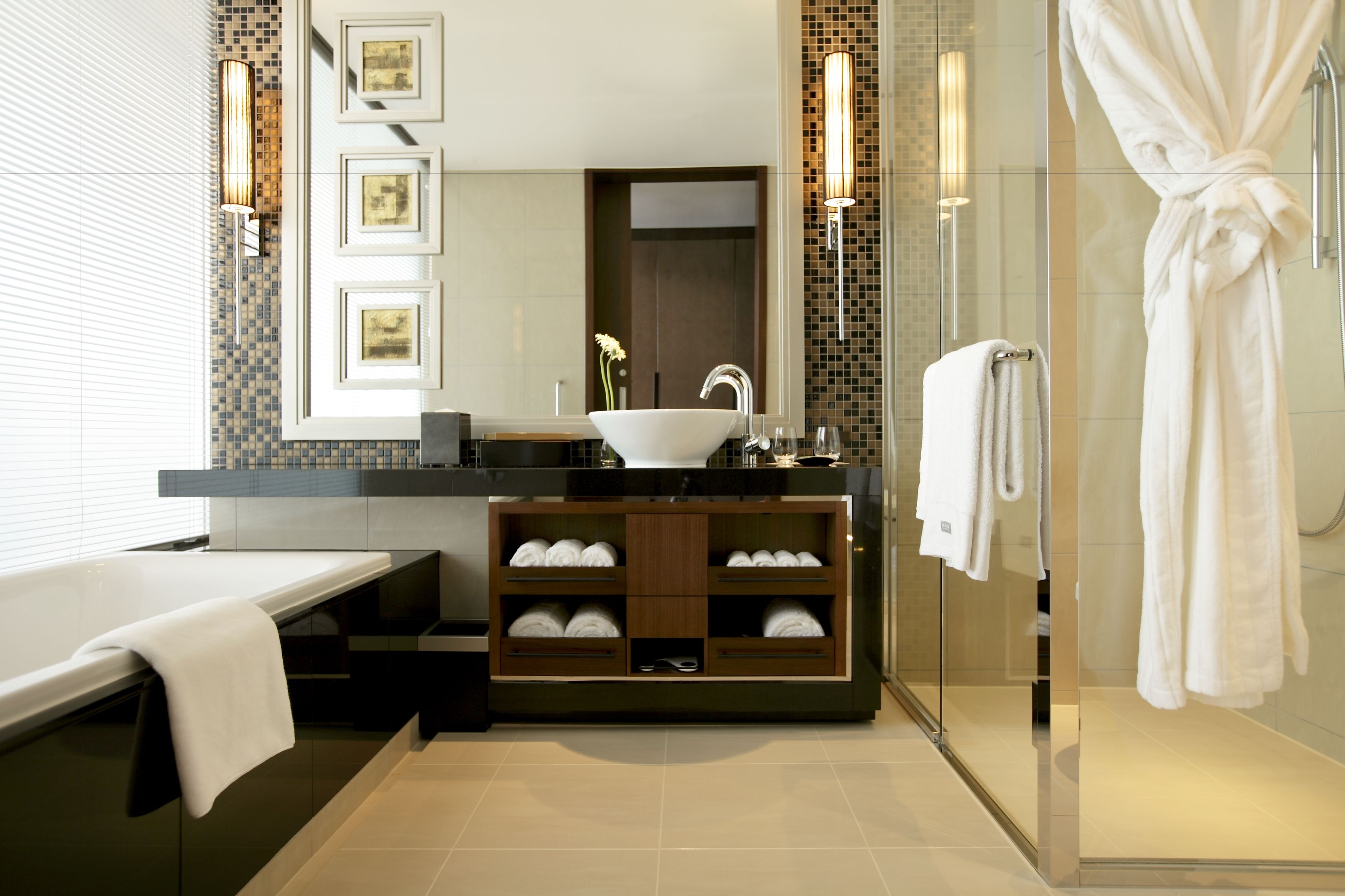 A modern bathroom with a large sink, a glass shower enclosure, and a bathtub.