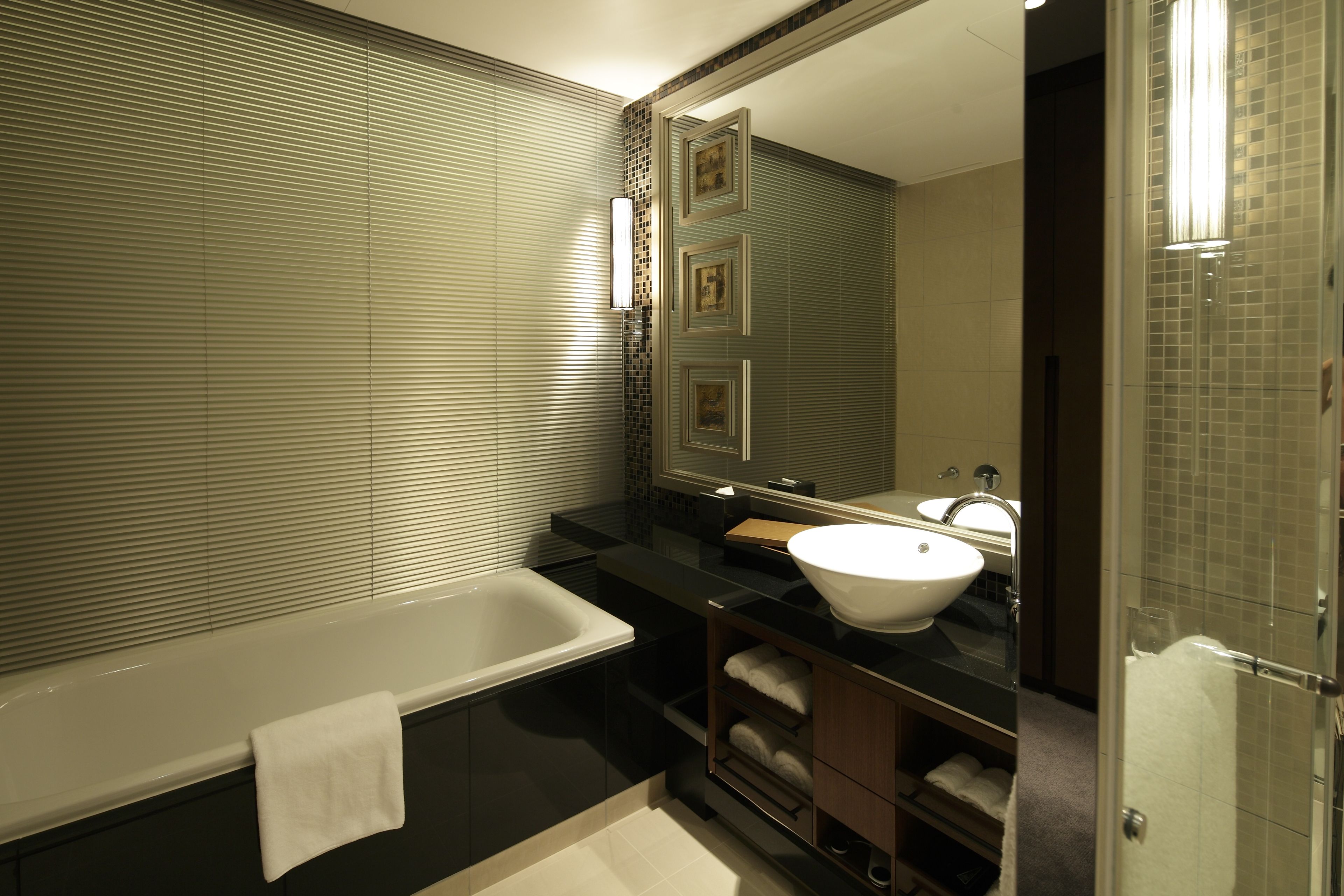Ein modernes Badezimmer mit Badewanne, Waschbecken und großem Spiegel.
