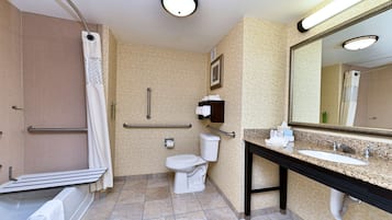 Un baño con ducha, inodoro, lavabo y espejo.
