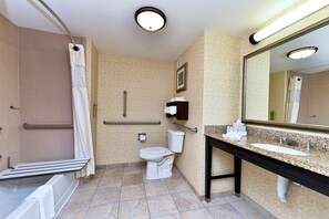 A bathroom with a shower, toilet, sink, and mirror.