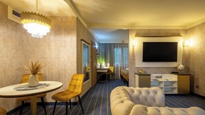A hotel room with a dining area, a sofa, a TV, and a minibar. - Hotel Diament Vacanza Siemianowice Slaskie (Siemianowice Slaskie)