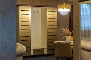 A hotel room with a walk-in closet, a dining area with a table and chairs, and a chandelier. - Hotel Diament Vacanza Siemianowice Slaskie (Siemianowice Slaskie)