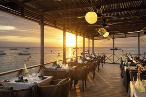 A restaurant with tables set for dining, overlooking the sea with boats in the distance. - Z Hotel & Z2 Hotel (Nungwi)