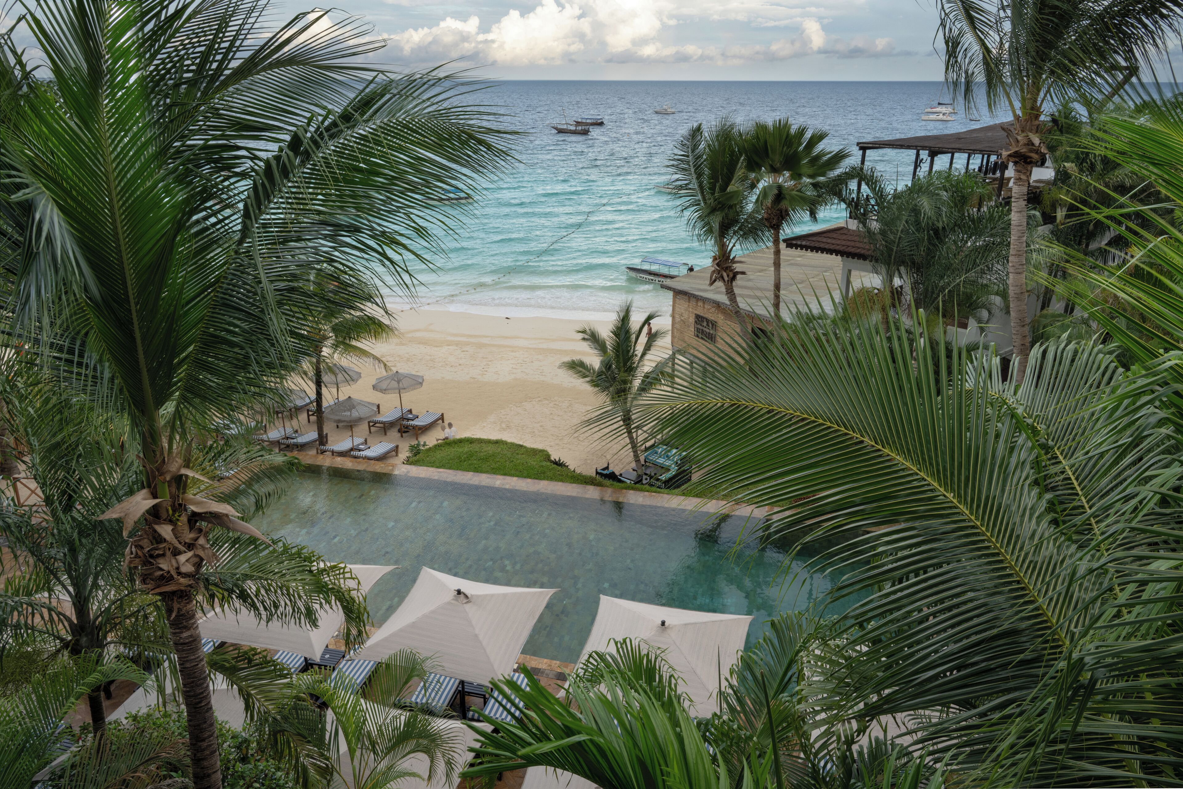 A resort with a pool, beach, and ocean view.