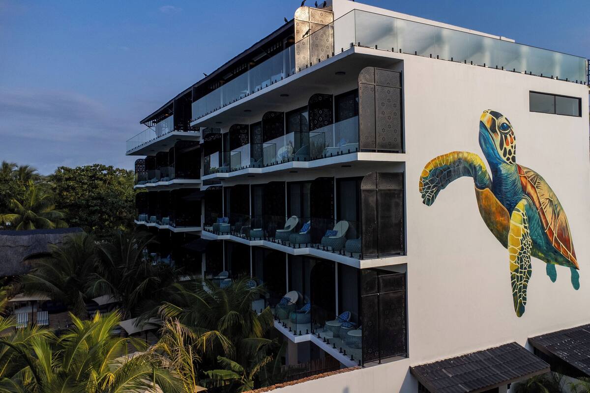 A modern building with a large mural of a sea turtle on the side.