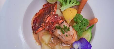 A seafood dish with lobster, shrimp, and vegetables on a plate.