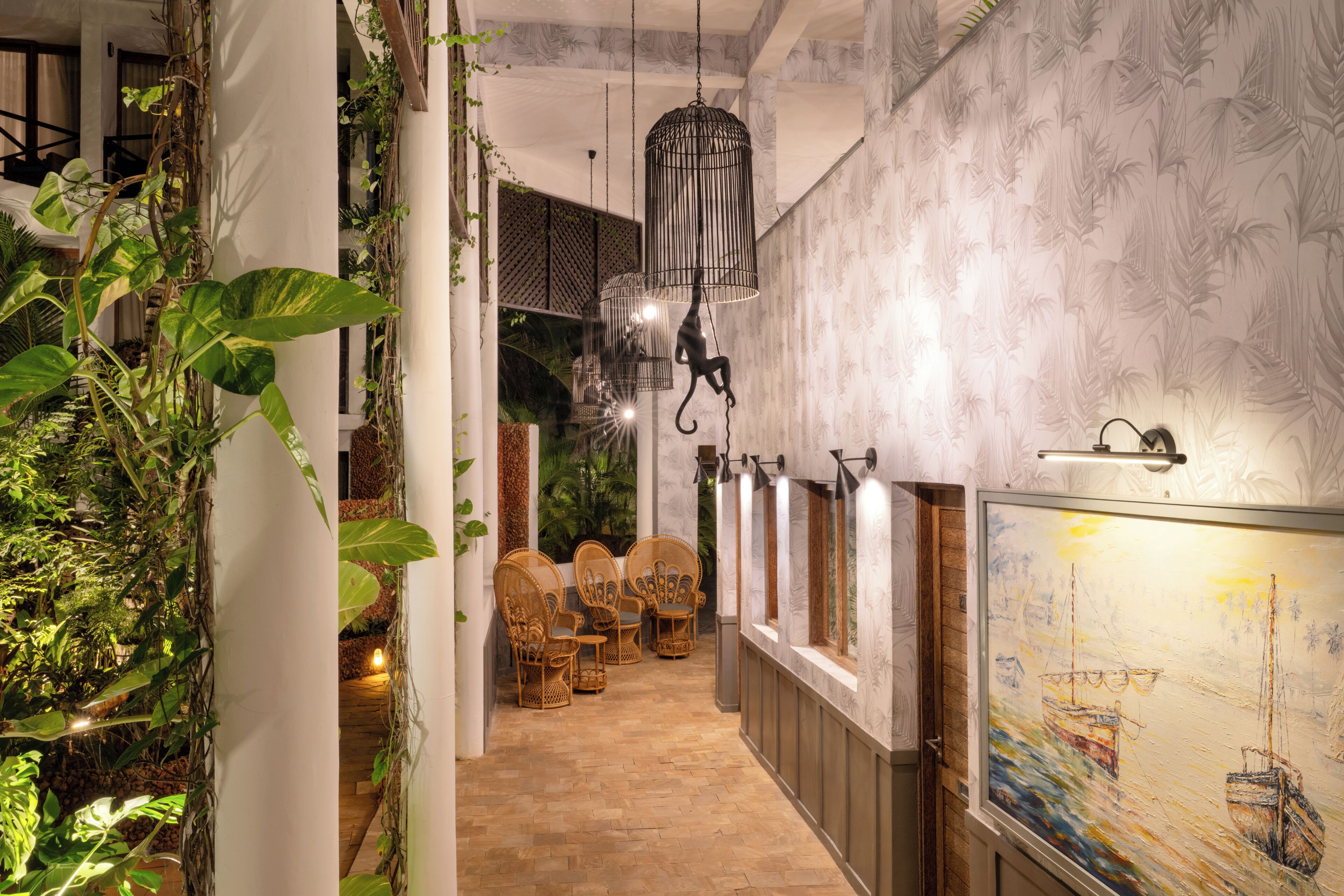 Un couloir doté d’un plancher en bois, de meubles en osier et d’un tableau accroché au mur.