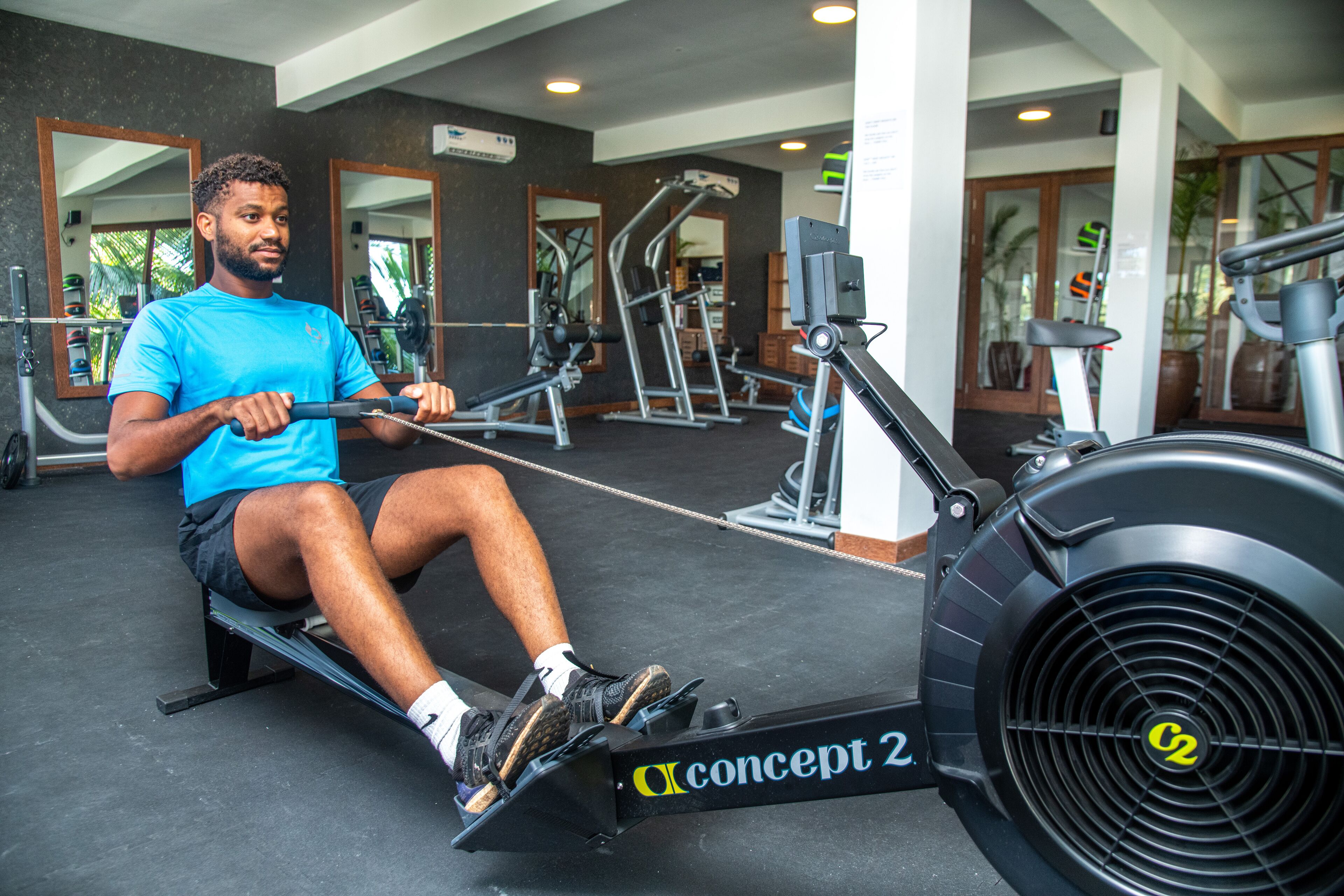 A gym with various exercise equipment, including a rowing machine and weight machines.