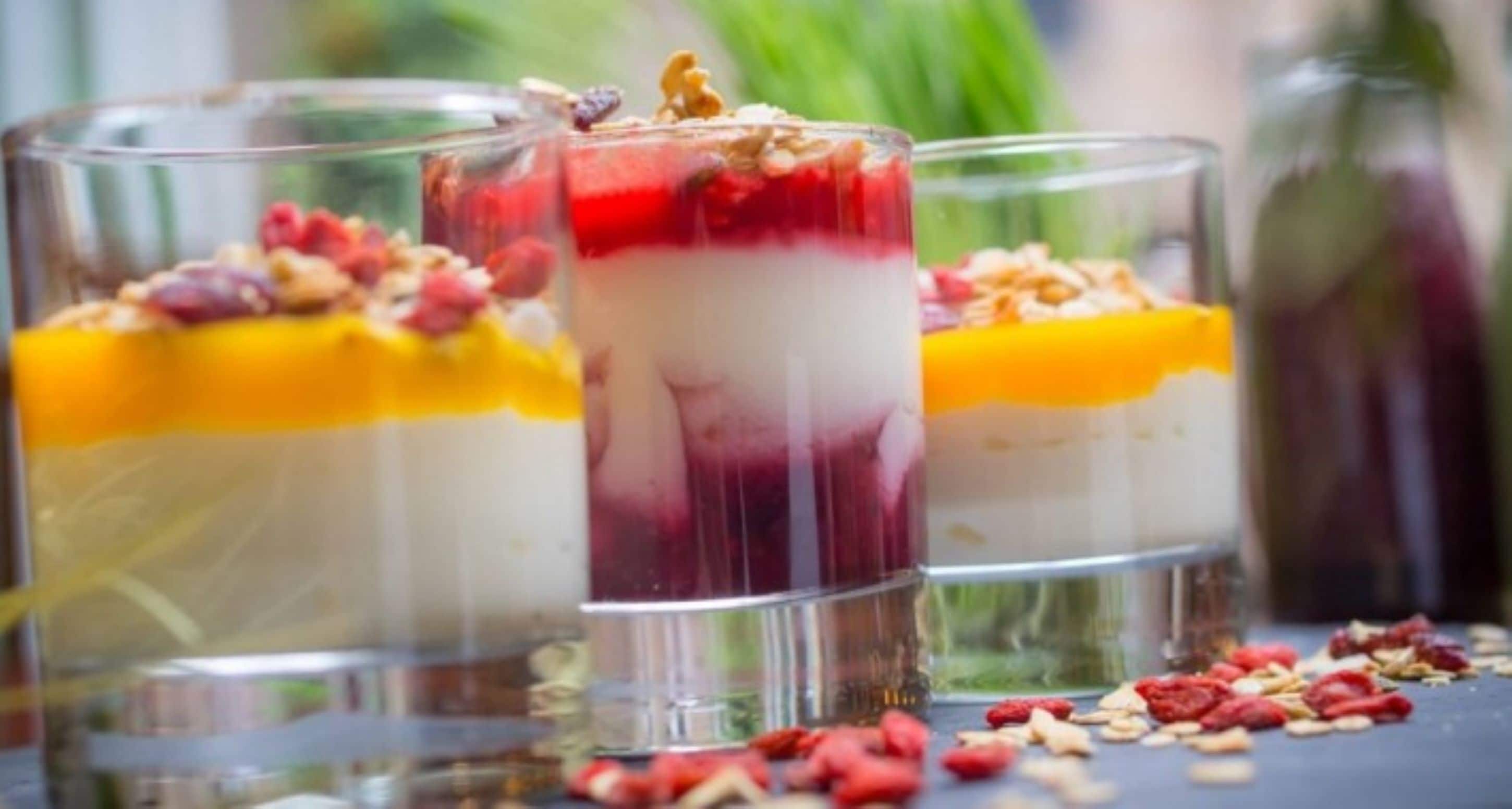 Drielagige desserts in glazen met fruit en noten.