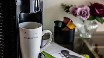 Una cafetera con una taza que dice "the gibson hotel" en su base.