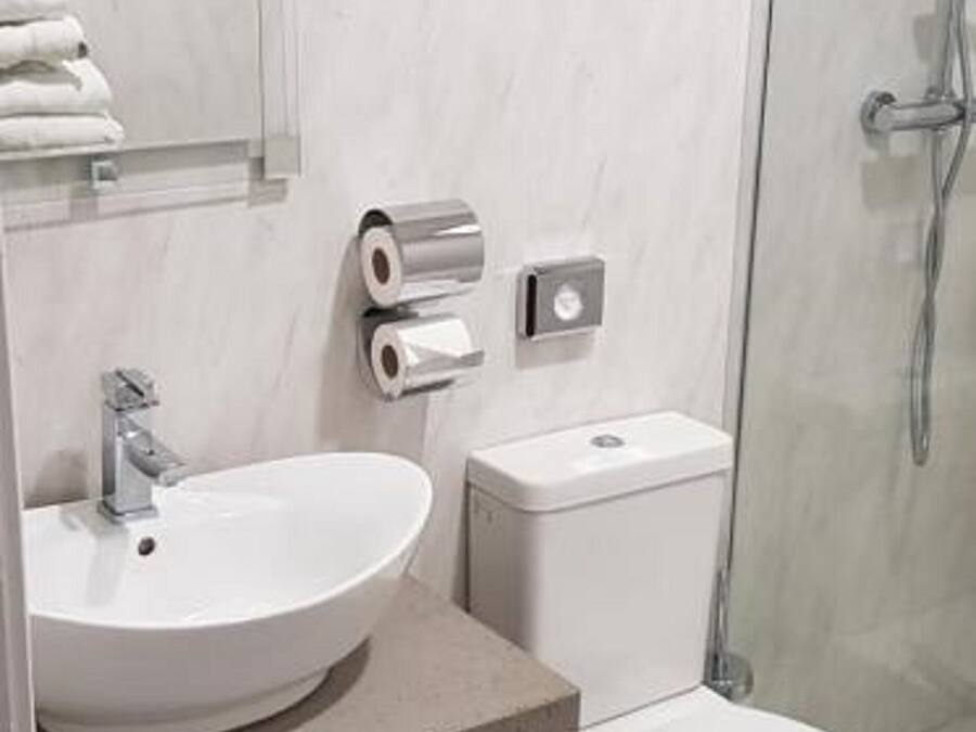 A modern bathroom with a sink, toilet, and shower.