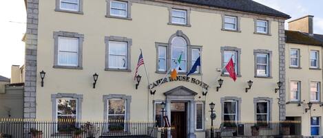 A hotel with a classic facade, multiple windows, and flags.