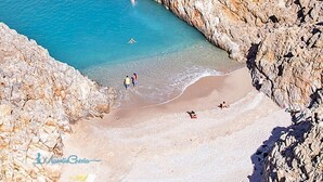 A beach with rocky cliffs and clear blue water. - Atlantica Yakinthos Hotel (Chania)