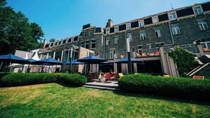 A courtyard with outdoor seating, stone building, and greenery.