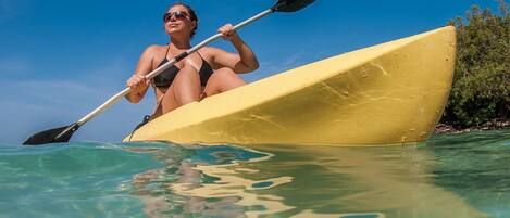 Una persona en kayak sobre aguas tranquilas.